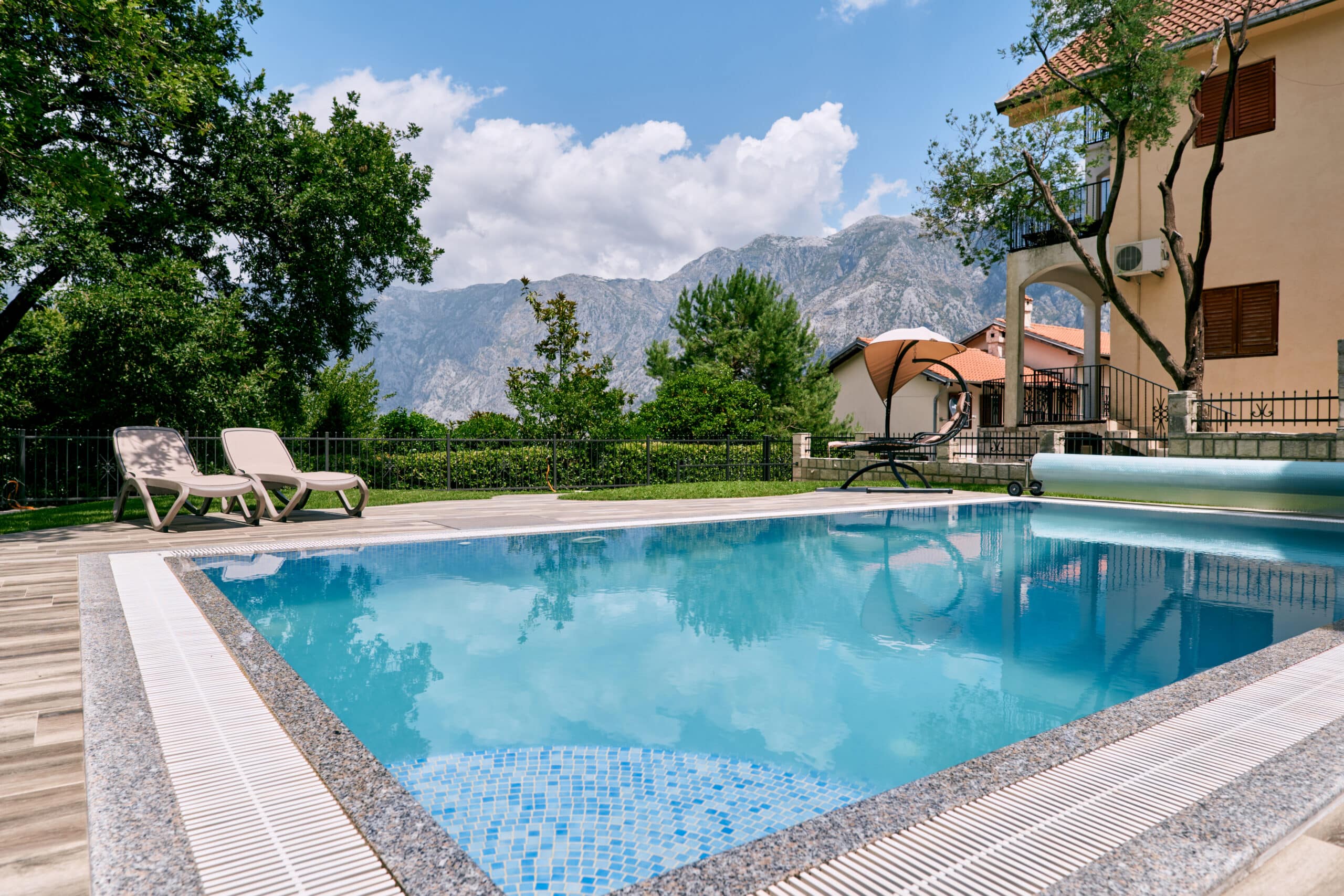 rectangular pool with turquoise water near the villa at the foot of the mountains